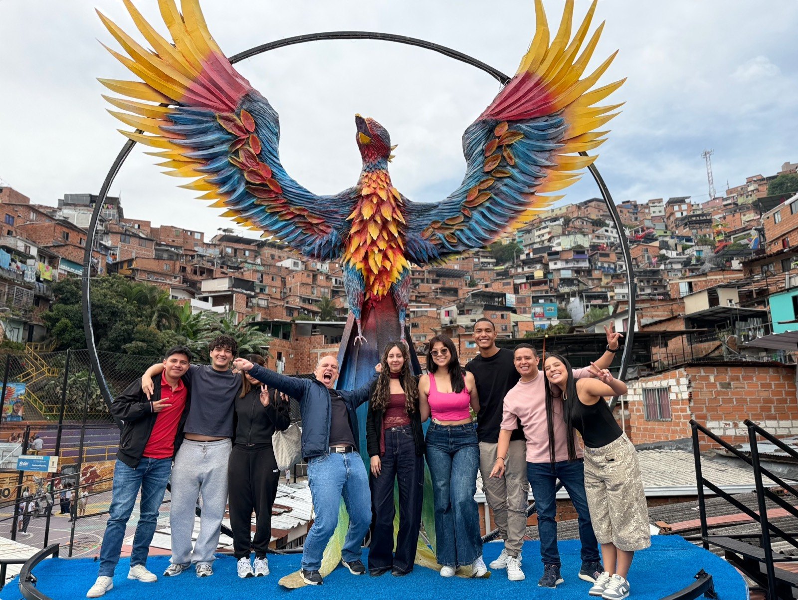 Grupo frente a la escultura del Fénix, con la ladera de la Comuna 13 de Medellín al fondo