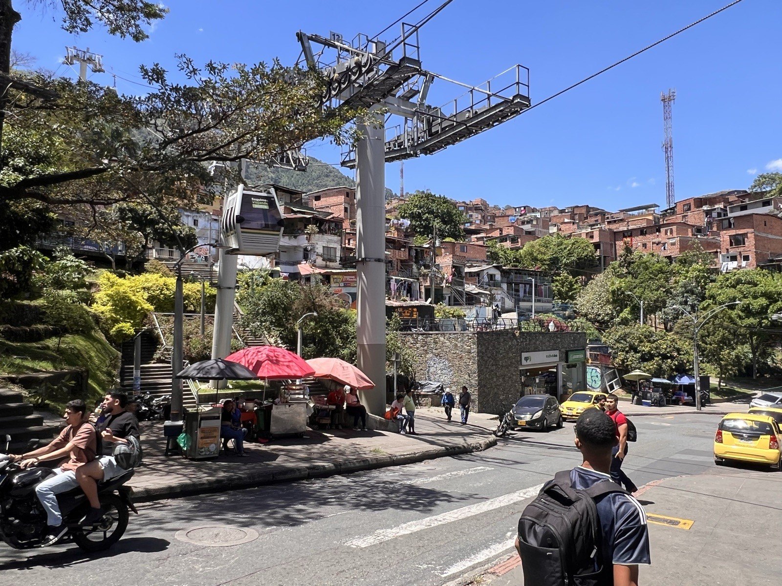 Estación del metrocable en el barrio Popular, Comuna 1 de Medellín, con la calle y las laderas de fondo